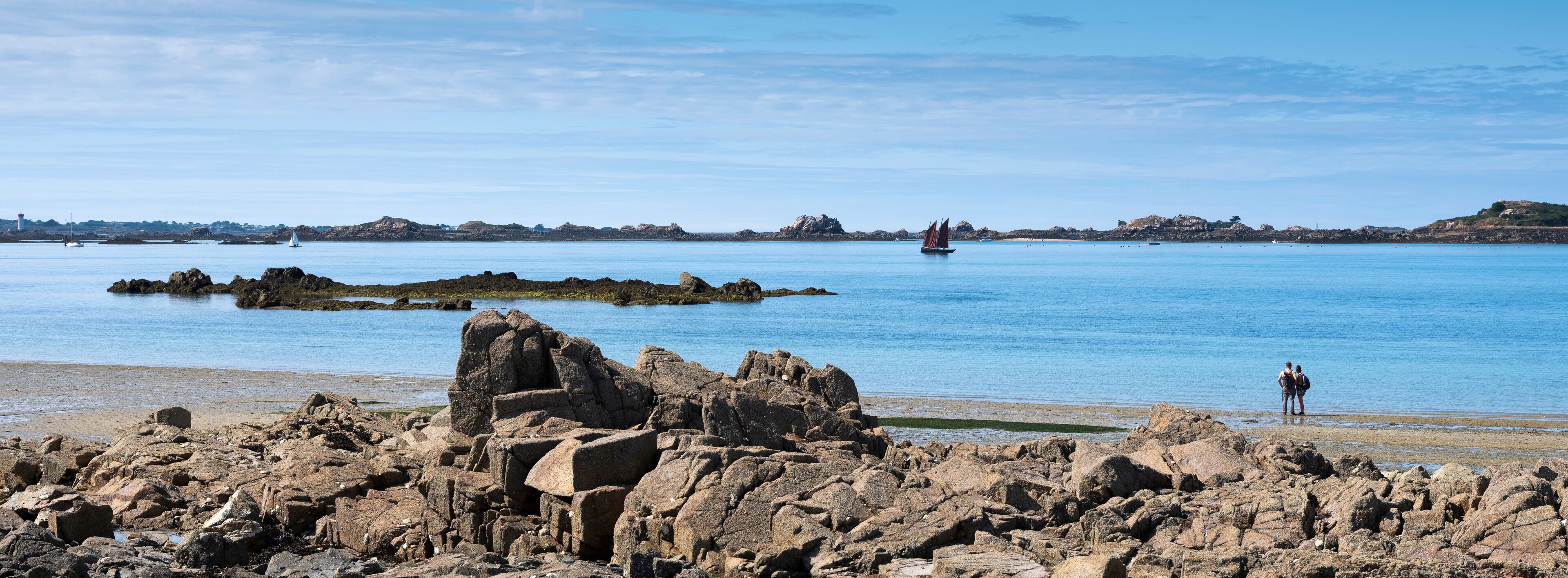 rocks and beach near ile de Bréhat in the north of brittany in france under blue sky