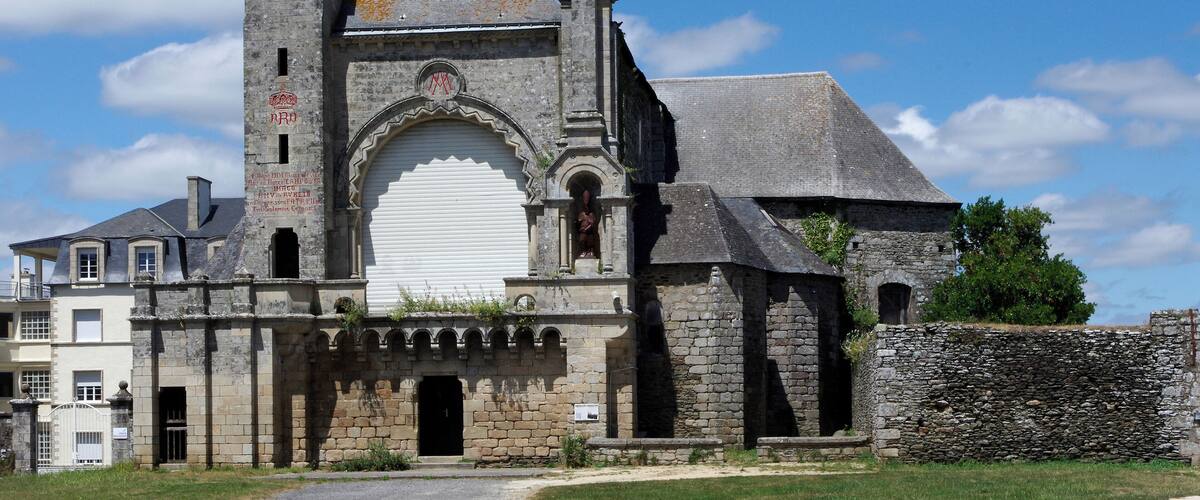 A historic stone church with a bell tower and a large arched entrance.