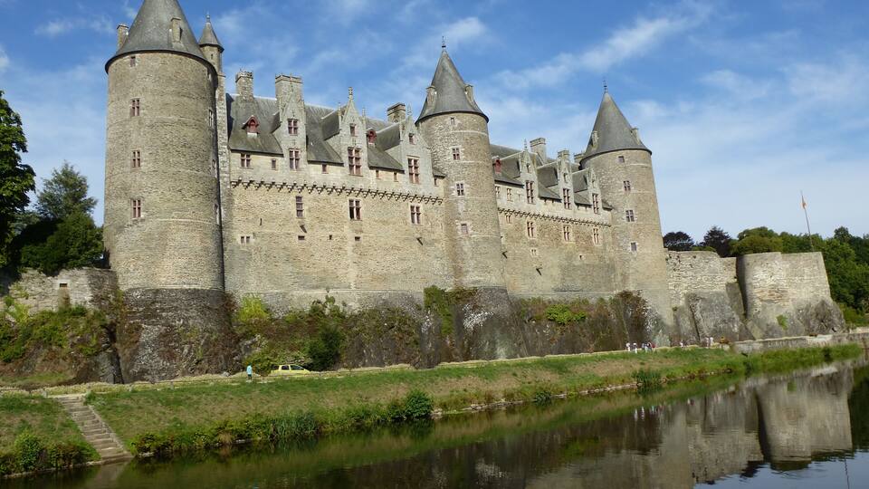 A historic stone castle with multiple towers and a moat.