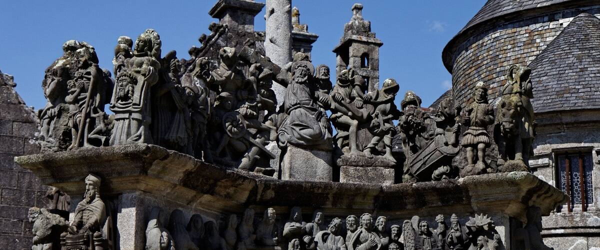 A detailed stone sculpture of historical figures and scenes on a building facade.