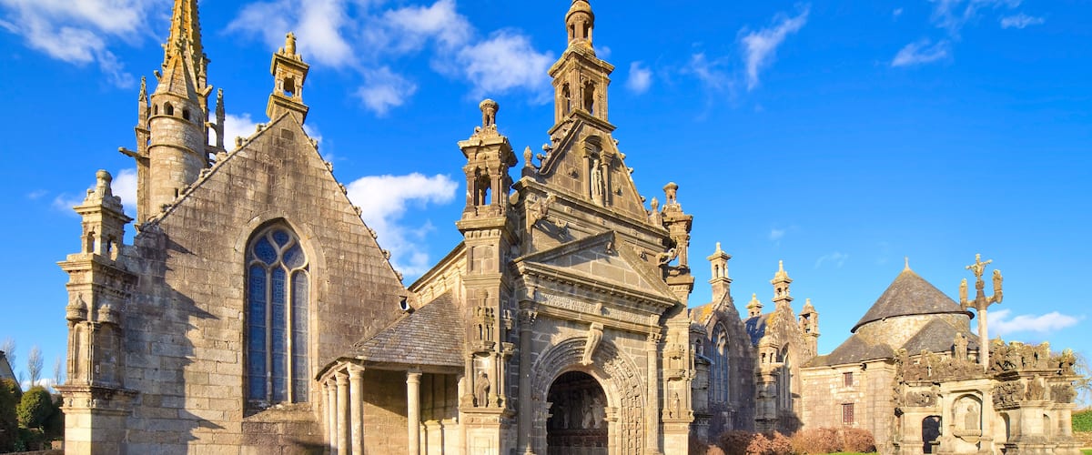 Una iglesia histórica con arquitectura intrincada, que incluye agujas y una gran entrada en arco.
