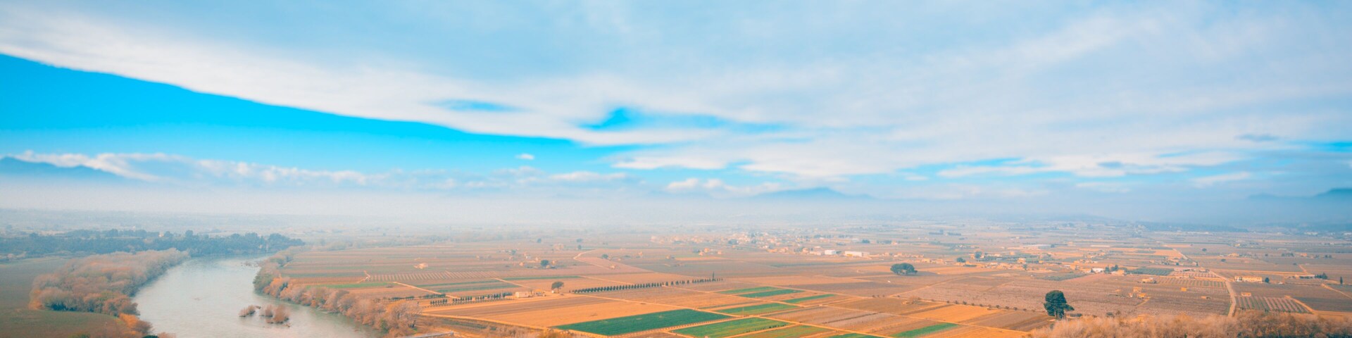 Ebro River in Spain, passing near Mora la Nova and Mora d'Ebre. Springtime view of fruit tree cultivation fields. teal and orange mood.