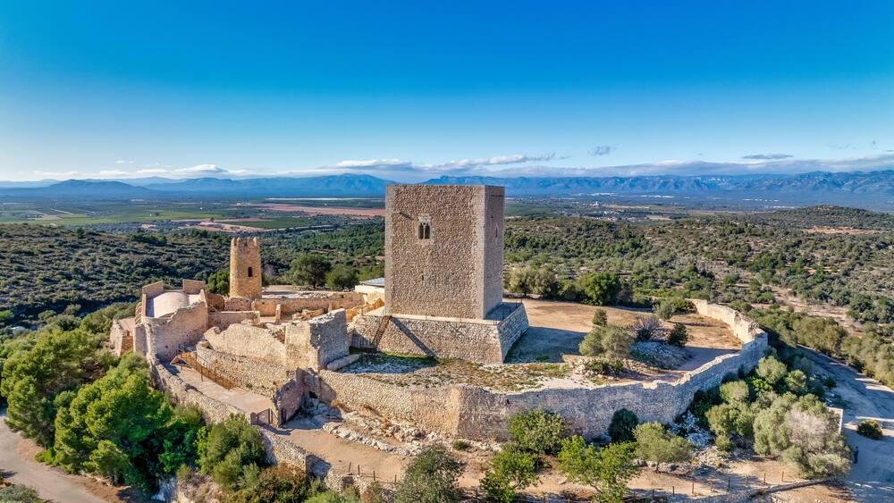 Aerial view of Ulldecona castle, Serra Grossa mountain top, former frontier fortified complex old church, emblematic circular tower and square keep