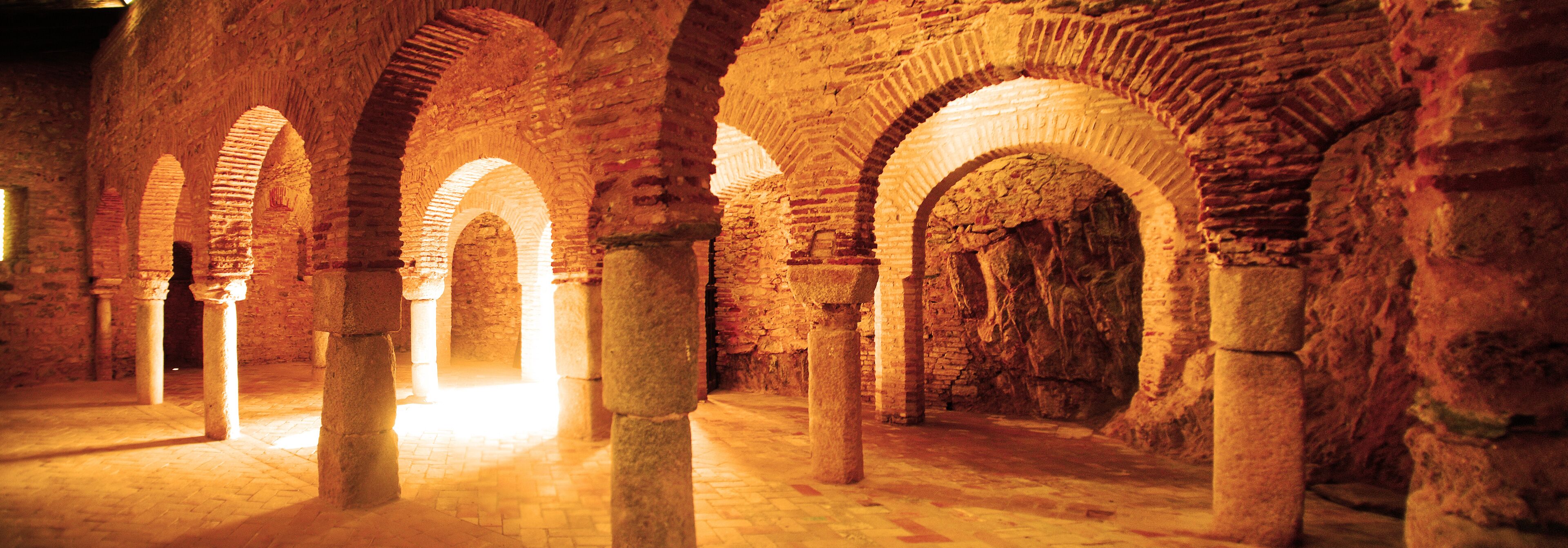 An ancient stone structure with arches and columns.
