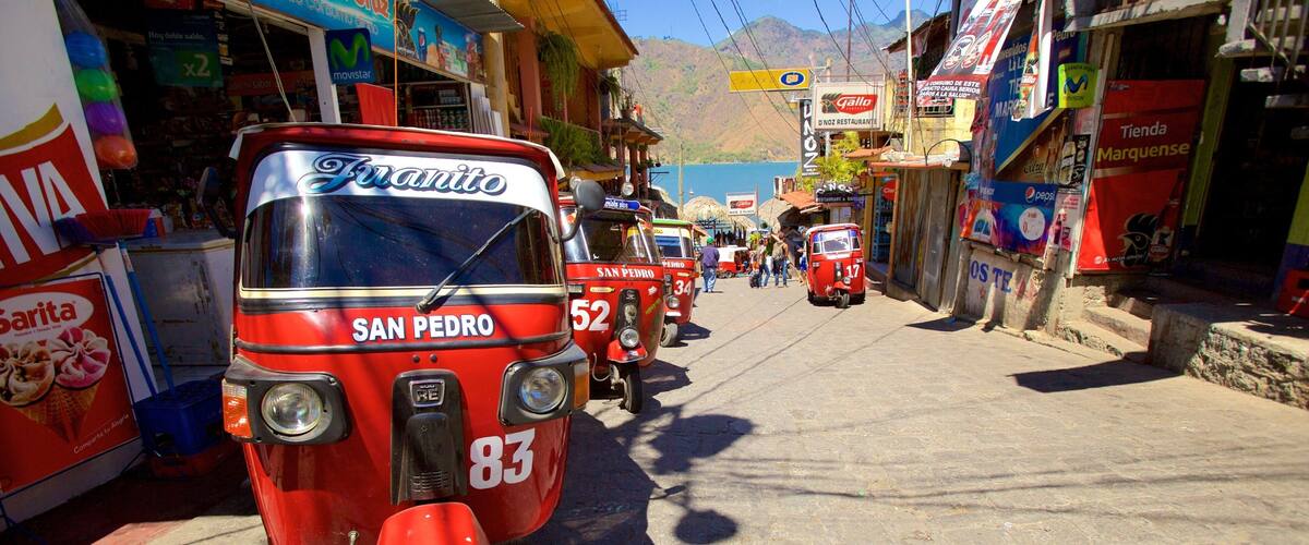 A red auto-rickshaw with the number 83 parked on a street.