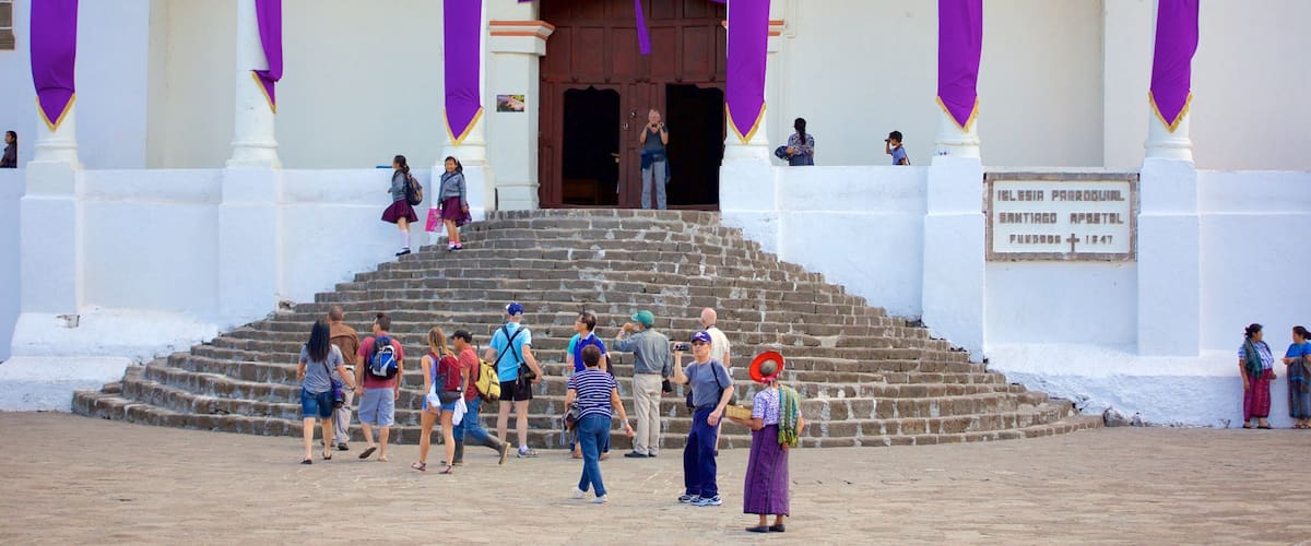 Una chiesa con drappeggi viola, una scala in pietra e un cartello che riporta "Ilesia Parroquial Santiago Apostol Fundada 1947".
