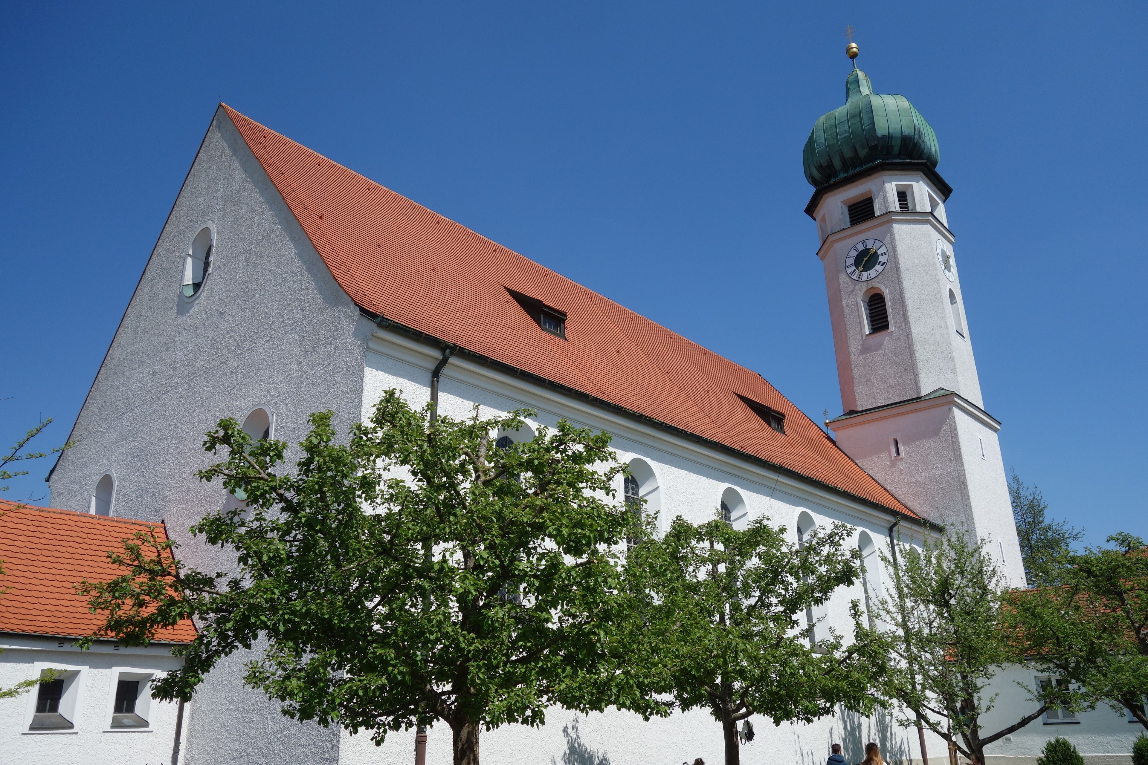 A church with a red roof and a clock tower.