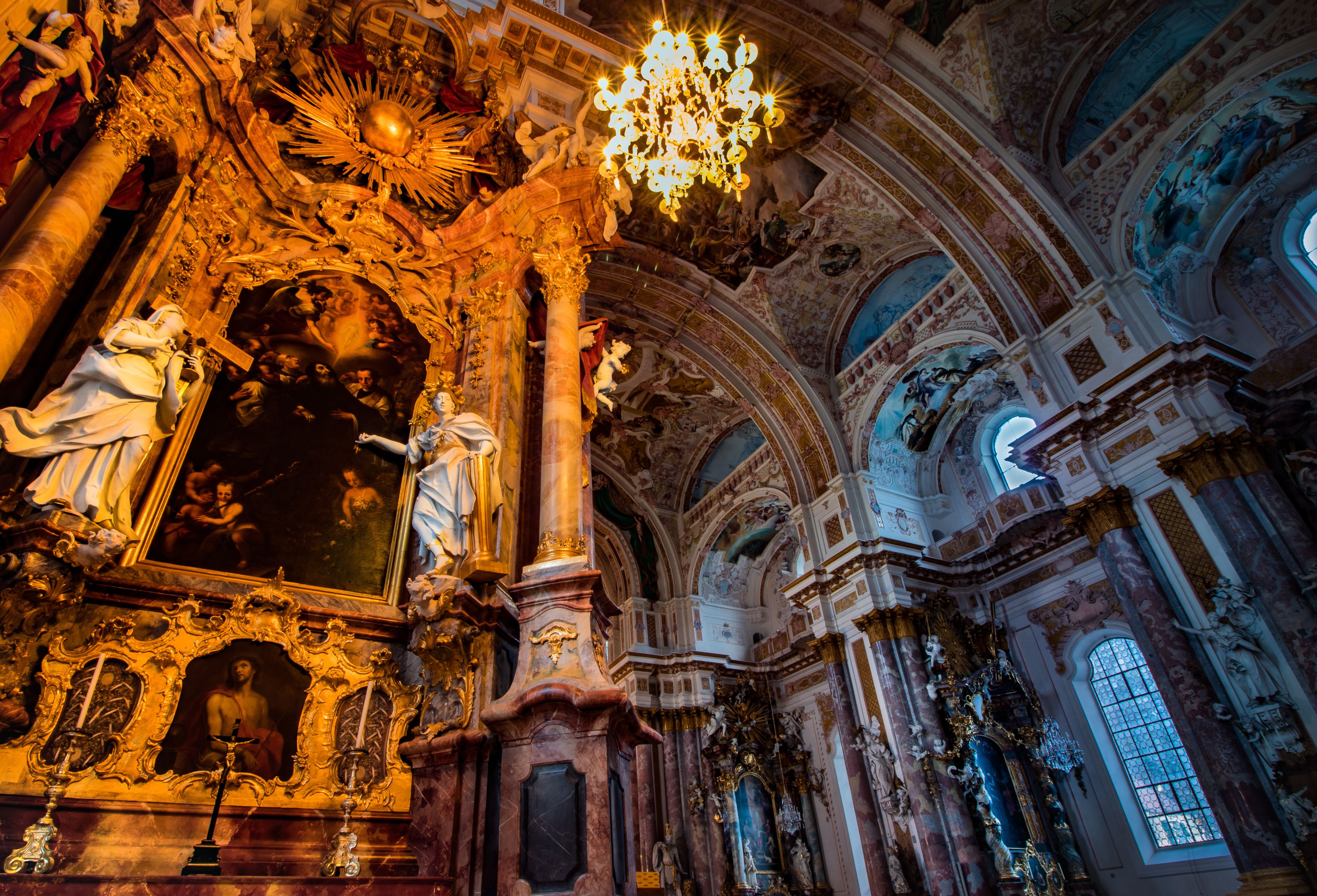 Ein prachtvolles Kircheninnere mit einem großen Chandelier, detailreichen Fresken und einem markanten Altar.