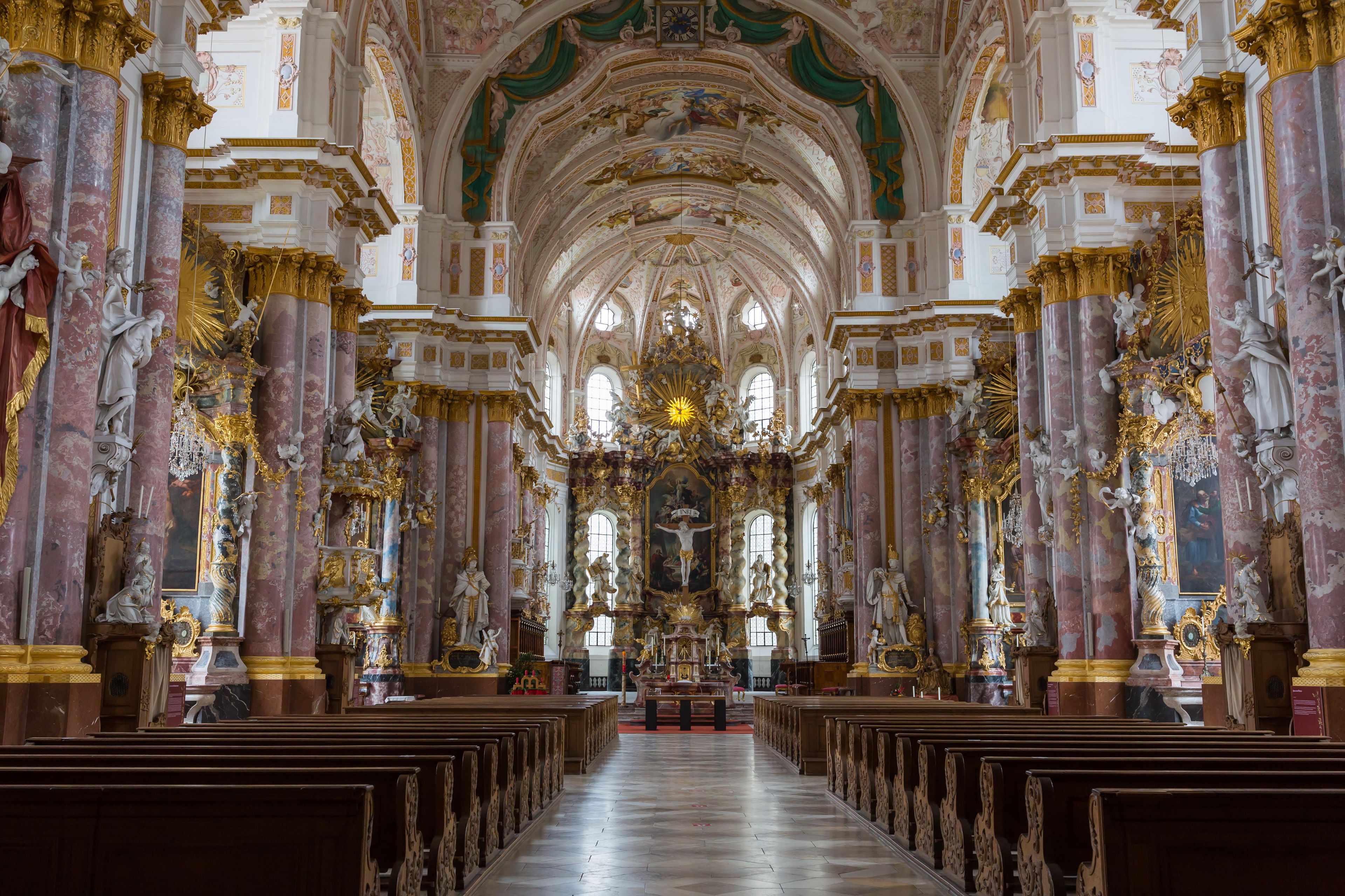 Ein prunkvolles Kircheninnere mit Marmorsäulen, Statuen und einem zentralen Altar.