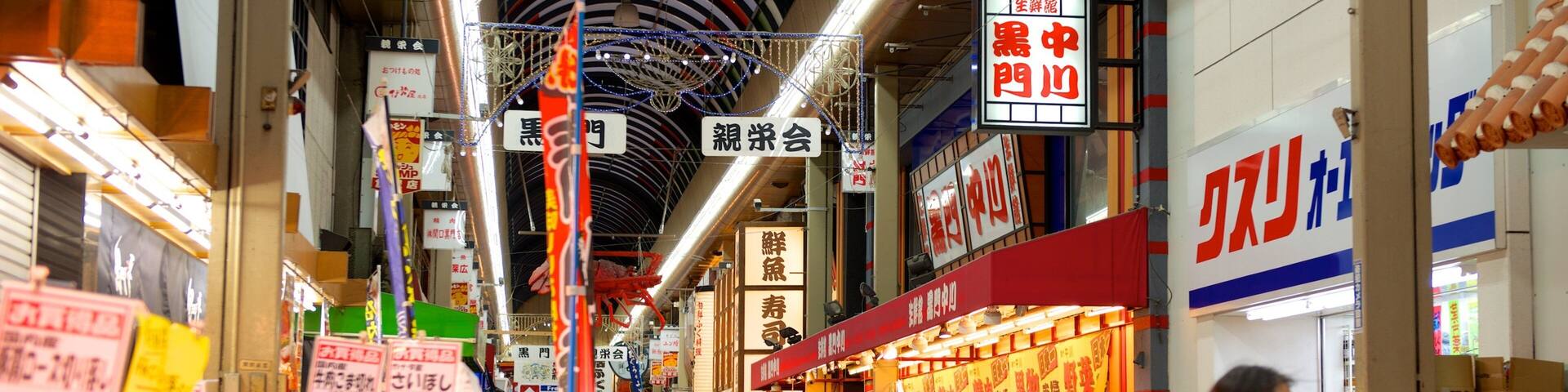 Kuromon Ichiba Market which includes a city and interior views as well as a large group of people