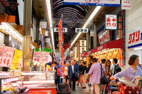 Kuromon Ichiba Market which includes a city and interior views as well as a large group of people