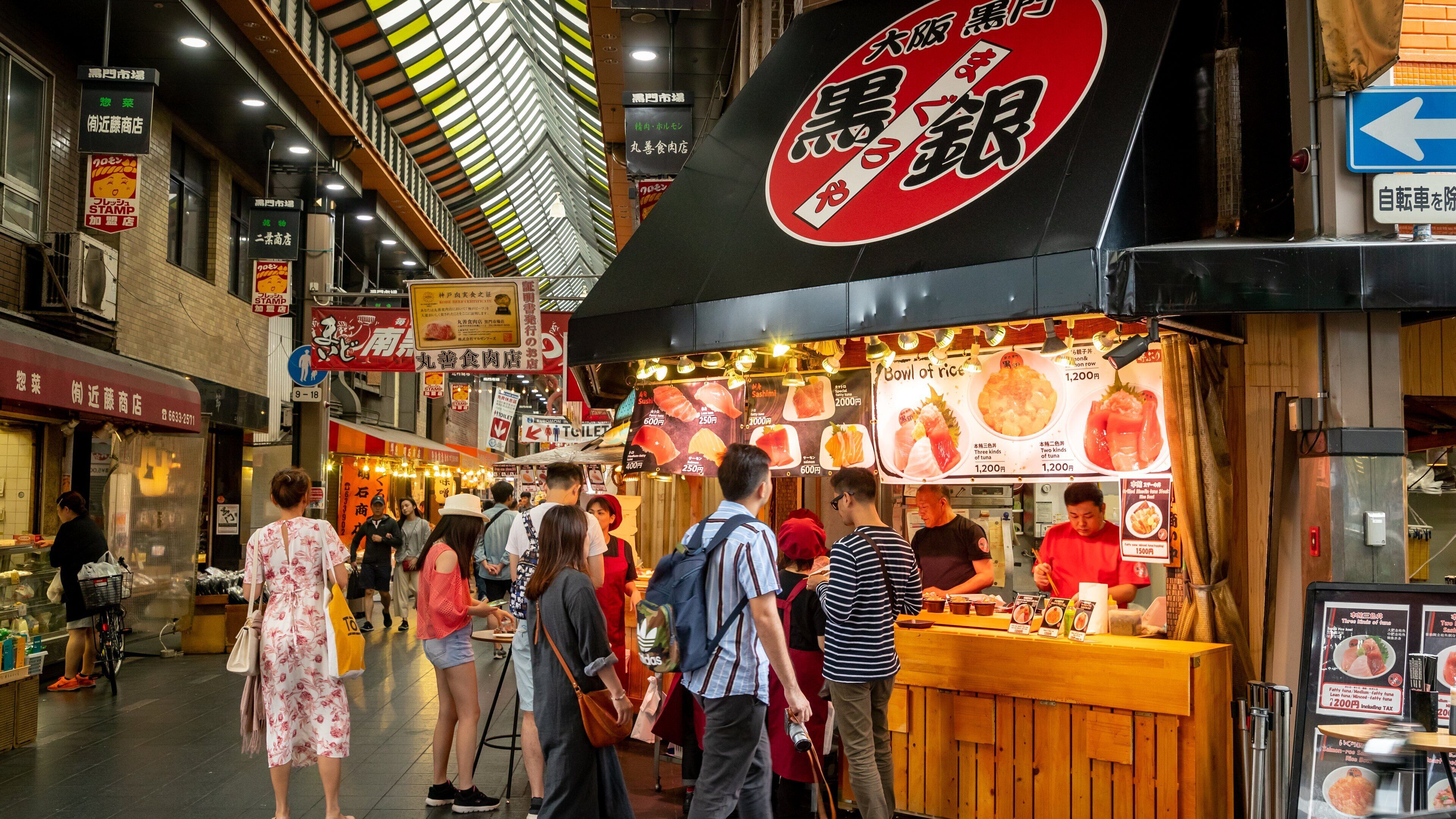 Kuromon Ichiba Market showing interior views and shopping as well as a small group of people