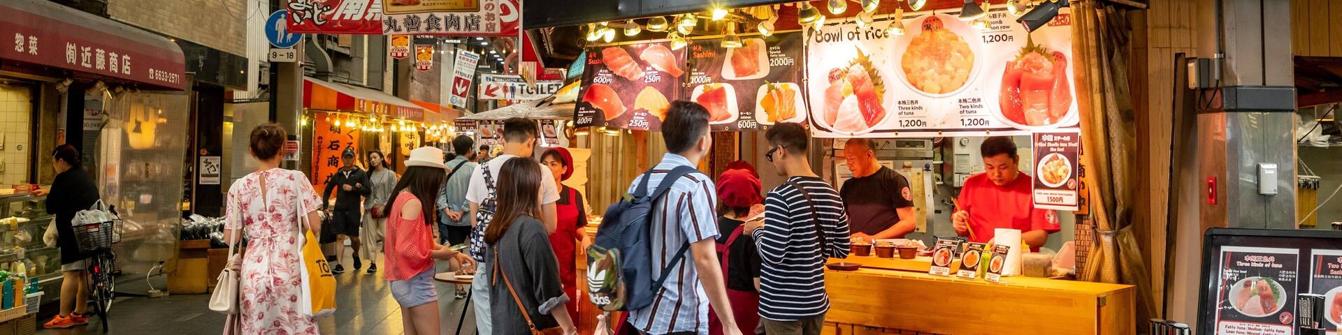 Kuromon Ichiba Market showing interior views and shopping as well as a small group of people
