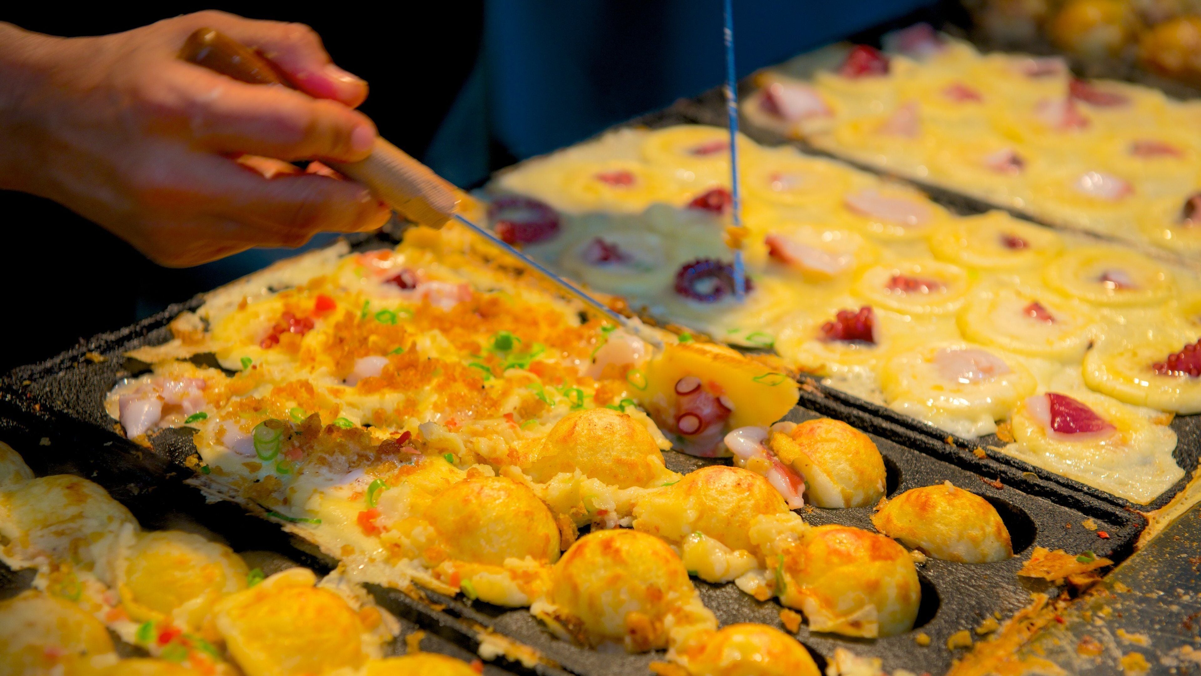A person cutting a dish with various toppings.