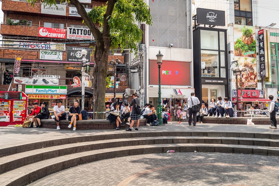 A busy urban square with people sitting and walking around.
