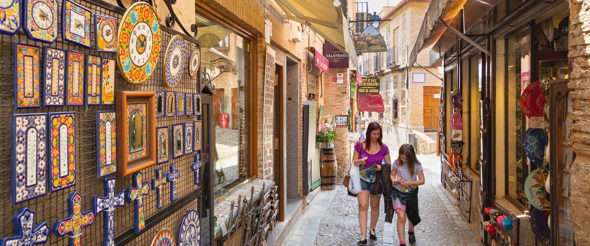 A narrow cobblestone street lined with colorful ceramic tiles and traditional shops.