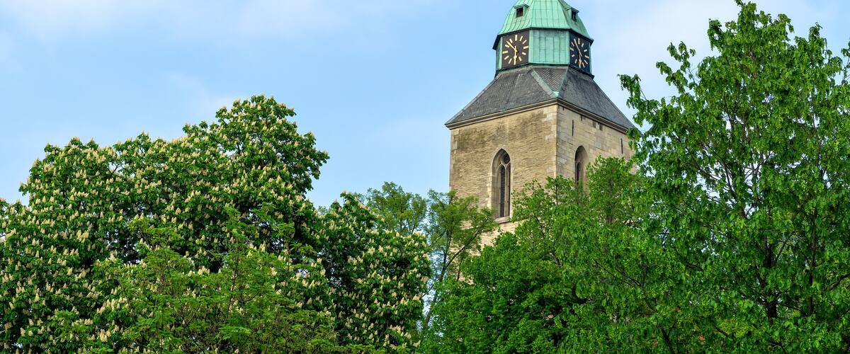 A church with a green spire and a clock tower.