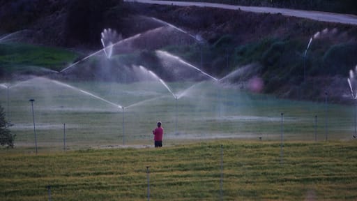 un hombre vigilando el buen funcionamiento del sistema de regadio en mollerussa, lerida, españa, europa