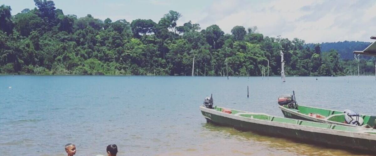 A lake with boats and people swimming.