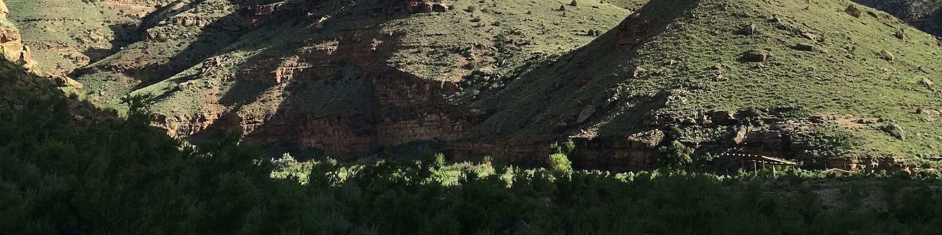 A mountainous landscape with a prominent rock formation and sparse vegetation.