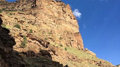 Beautiful mountains with deep blue skies and a few puffy clouds up 9 Mile Canyon, Helper, Utah. warm golden hour light illuminates a mountain cliff in the late afternoon, Nine Mile Canyon, Utah.