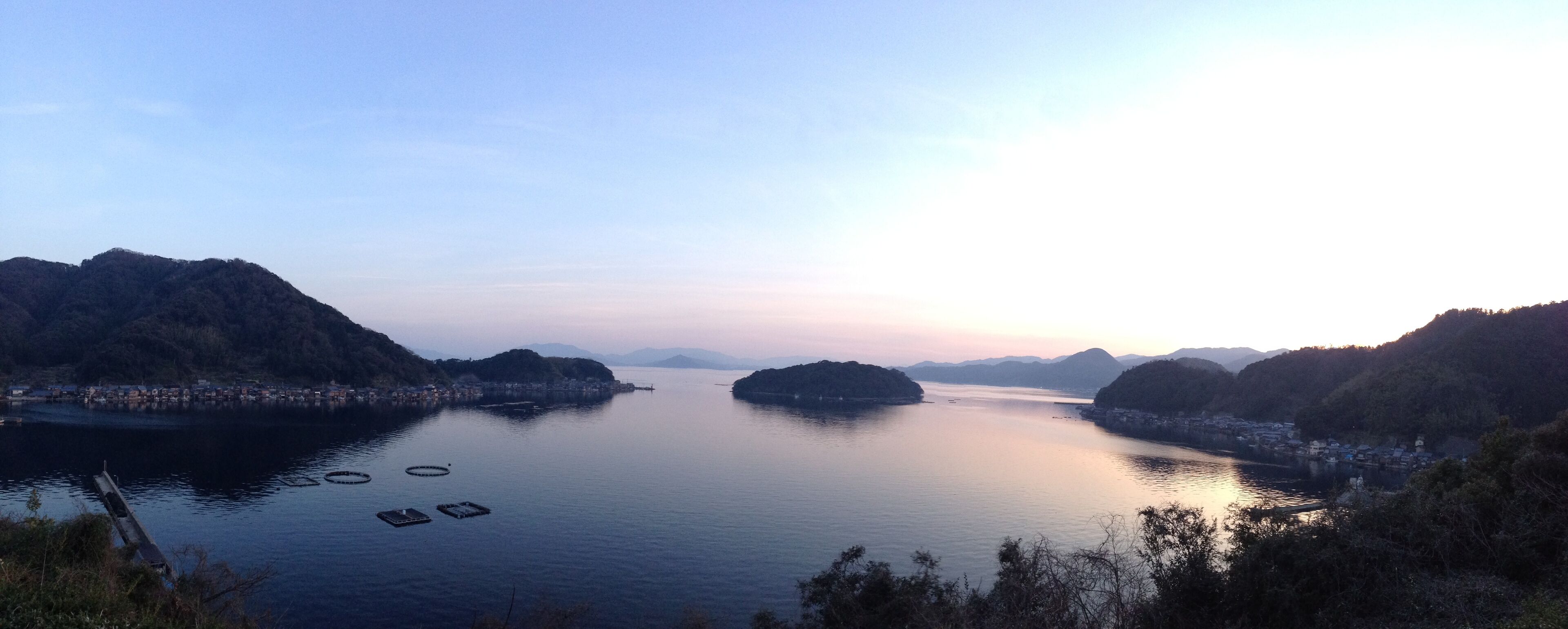 A calm river with several small islands and a distant shoreline with buildings.