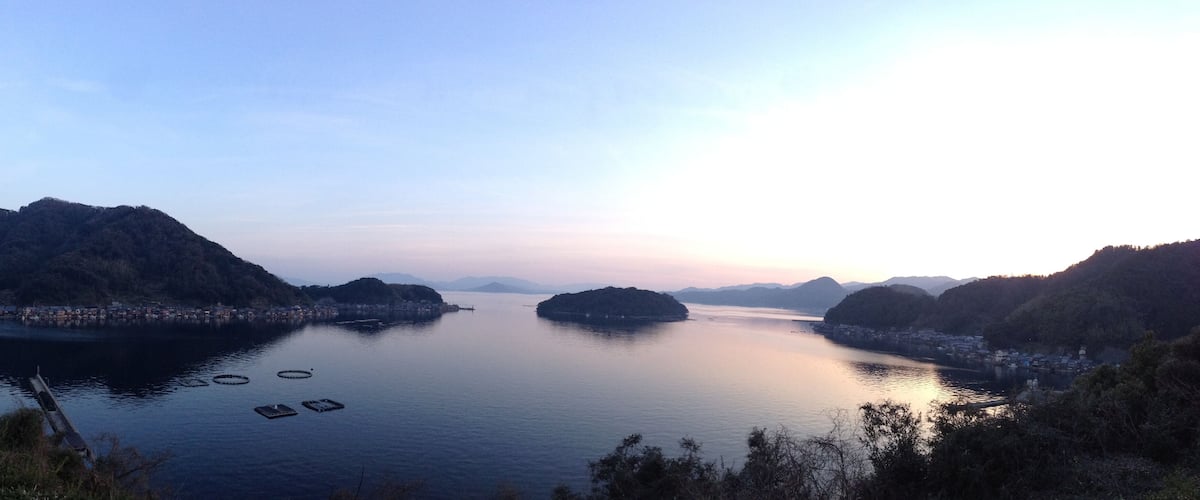 A calm river with several small islands and a distant shoreline with buildings.