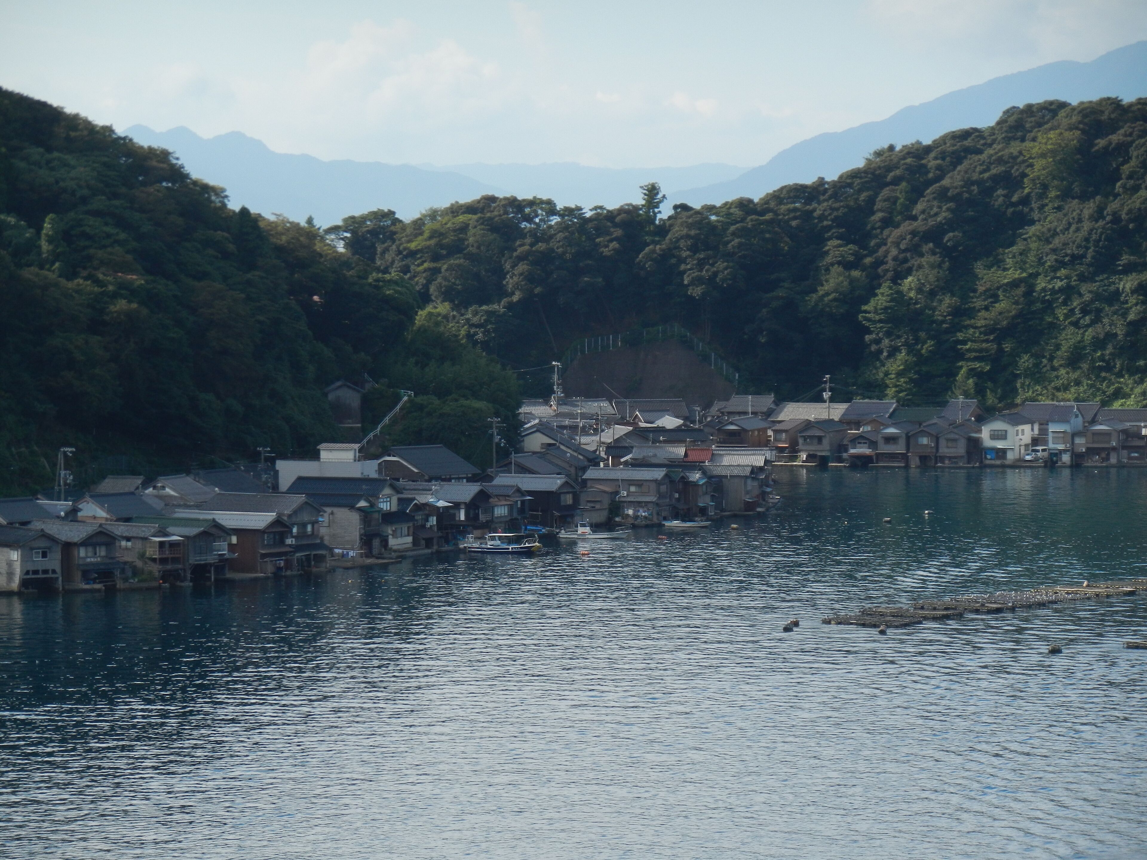 A riverside village with traditional houses and boats.