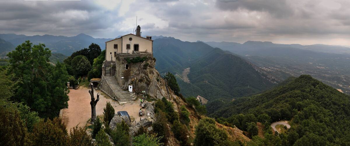 A stone building on a mountain peak with a view of the surrounding landscape.