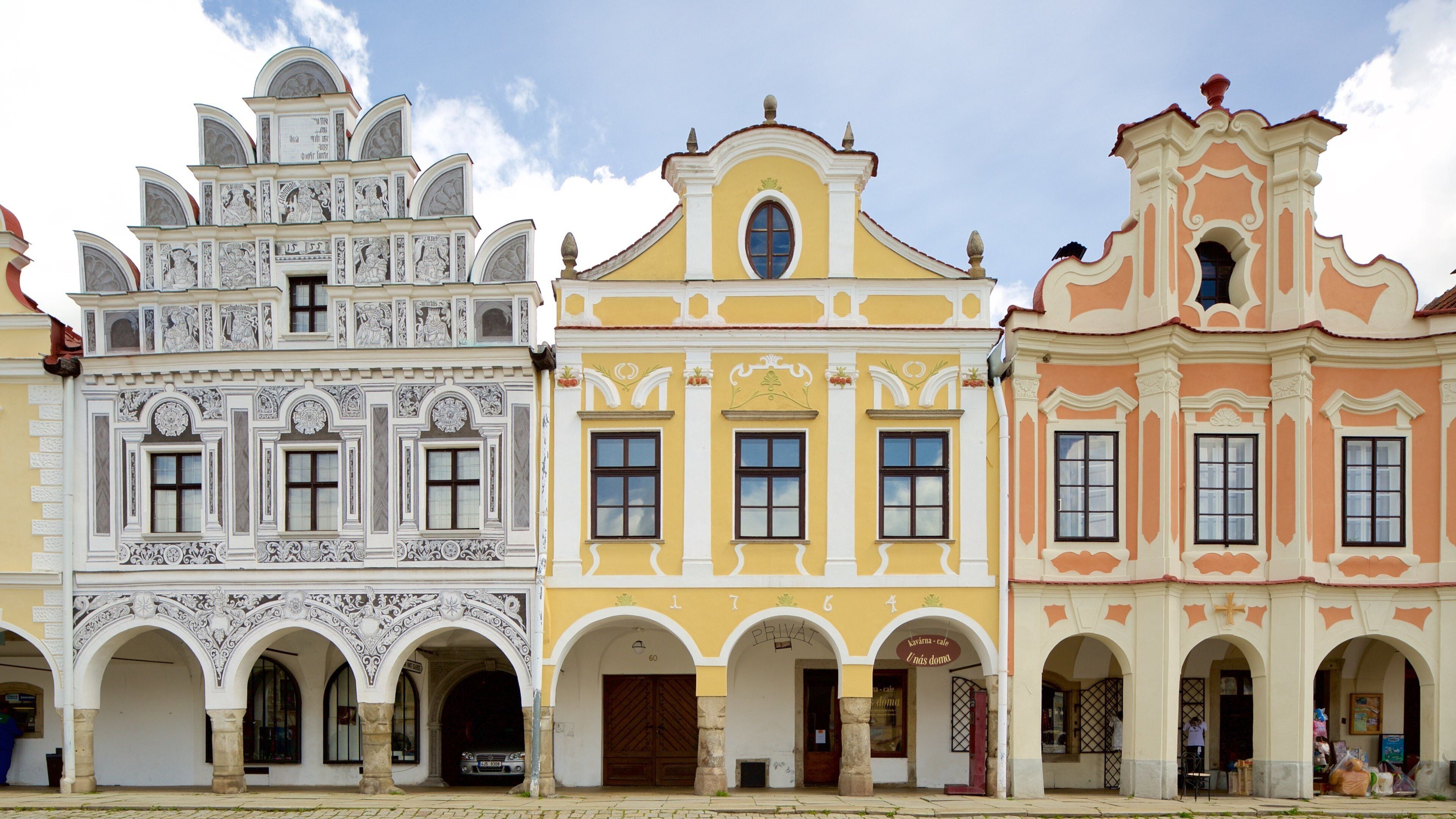 A row of colorful buildings with intricate architectural details and arched doorways.