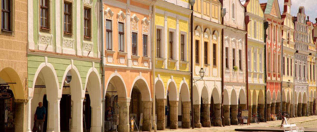 A row of colorful historic buildings with arched doorways and a cobblestone street.