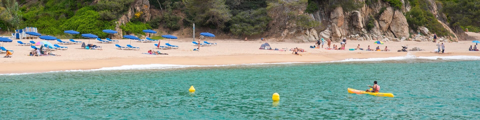 Cala Canyelles Beach featuring rocky coastline, a sandy beach and general coastal views