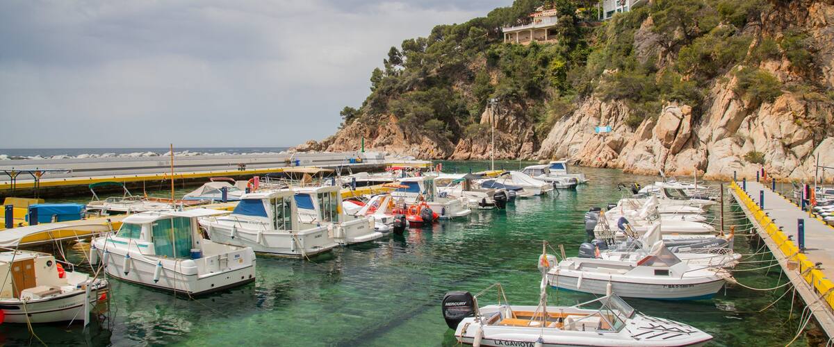 Canyelles Beach which includes rocky coastline and a bay or harbor