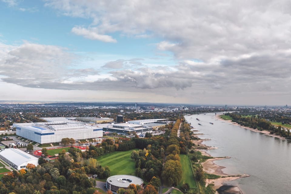 Eine Vogelperspektive auf eine Stadt mit einem Fluss, einem großen Stadion und umliegender Vegetation.