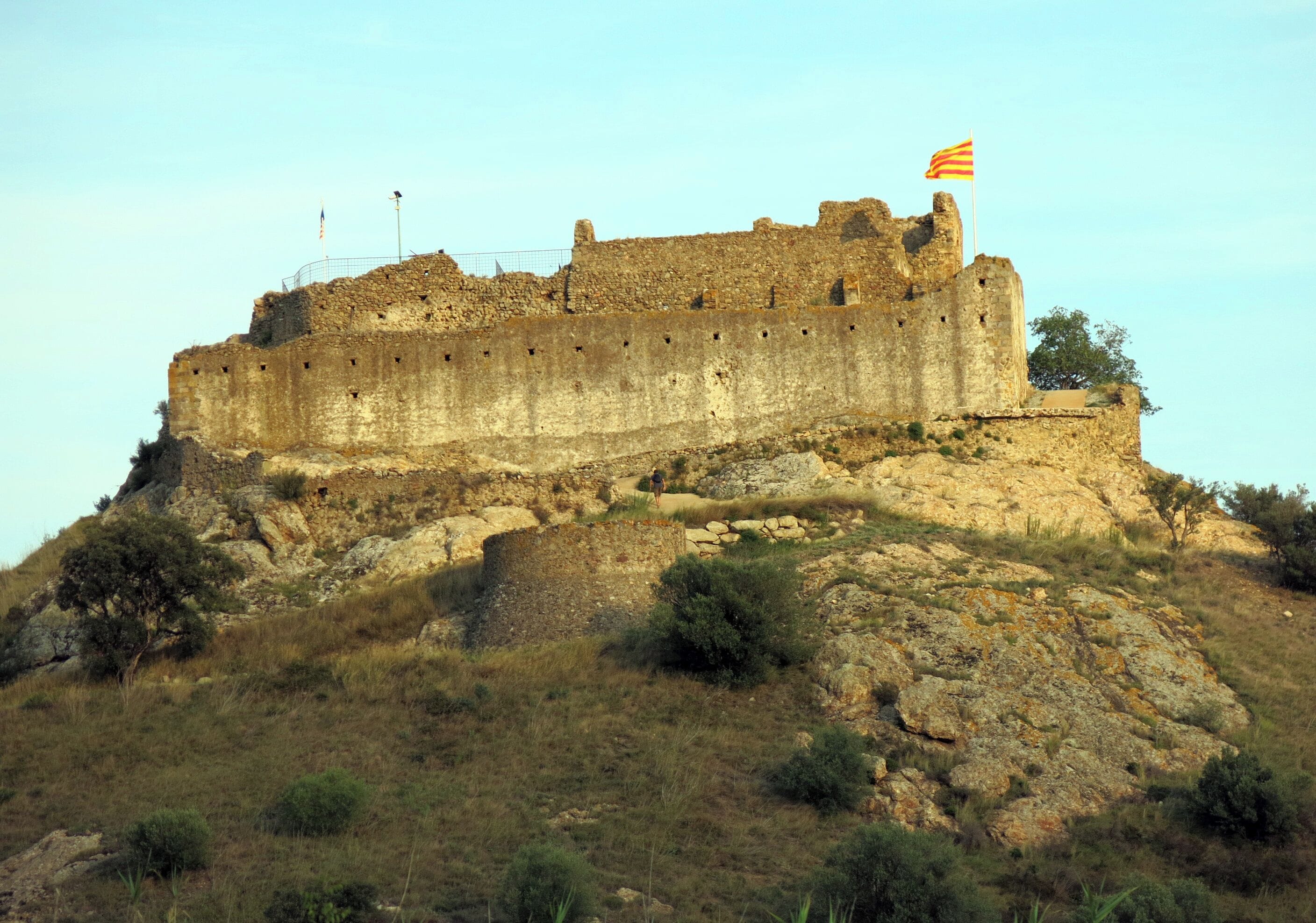 Eine historische Steinschlossburg auf einem Hügel mit einer Flagge.