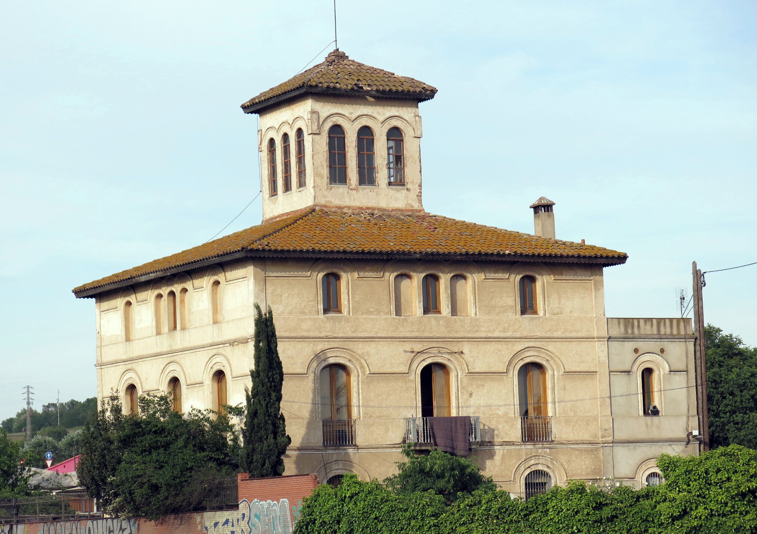 A historic building with a tiled roof, arched windows, and a bell tower.