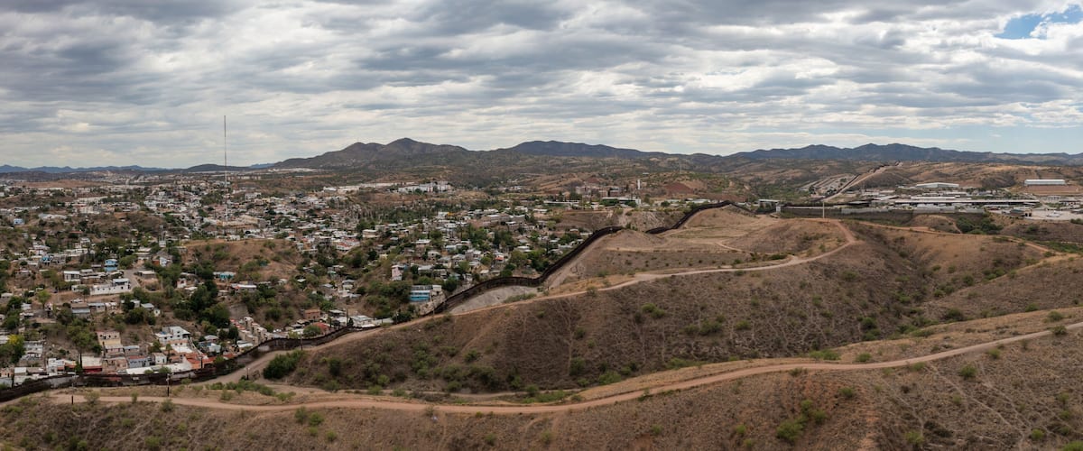 A town nestled in a valley with mountains in the background.