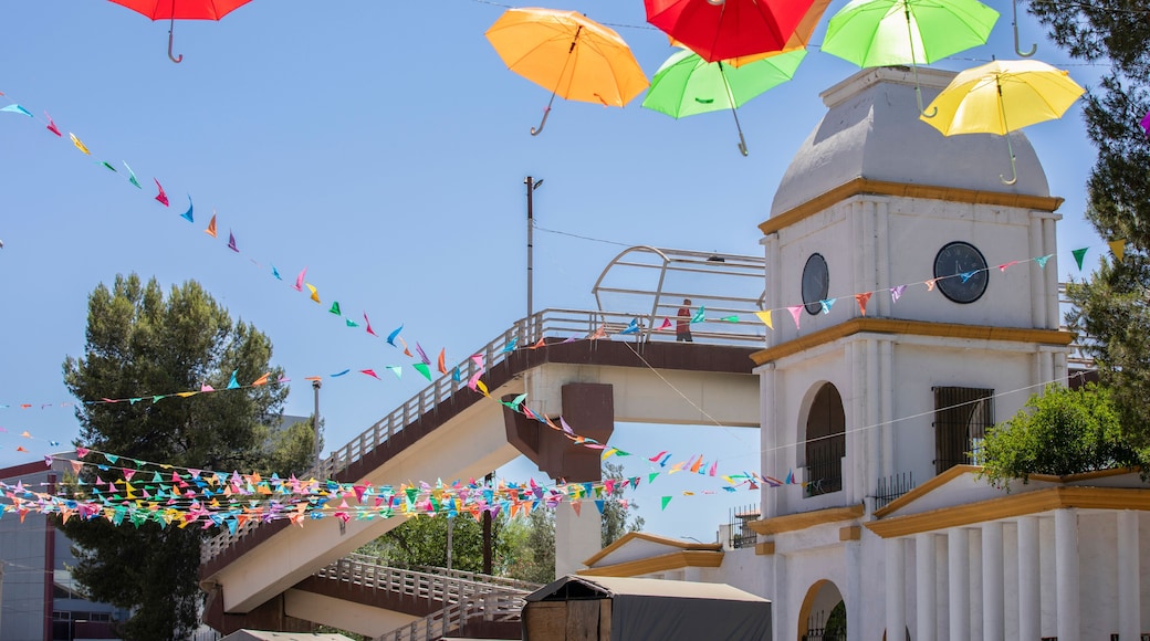 Colorful papel picado frames the historic clock tower of the downtown train station in Heroica Nogales, Sonora, Mexico.