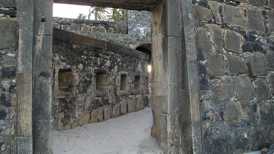 An ancient stone structure with rectangular openings and a stone archway.