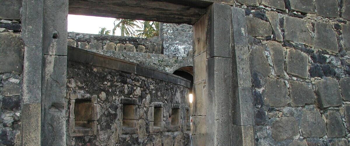 An ancient stone structure with rectangular openings and a stone archway.