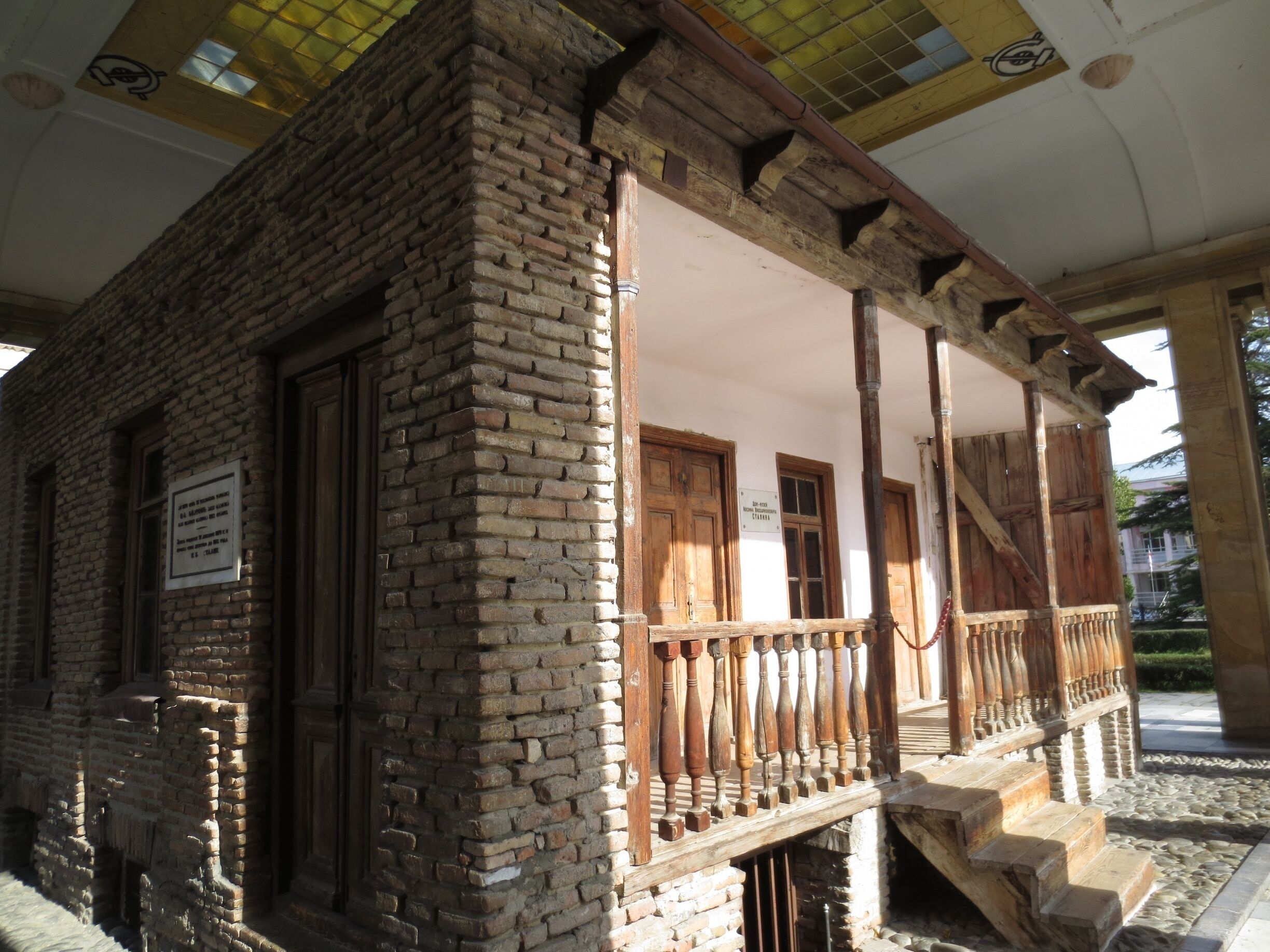 #architecture Joseph Stalin's boyhood home.  View from the Joseph Stalin Museum in the city of Gori, Georgia.

Joseph Stalin, former leader of the USSR, was born in raised in a small town called Gori, Georgia.

The picture here is of his the small home where he spent his formative years.  Although the rest of that neighborhood was demolished, his home was saved, and entombed in a structure to protect it from the elements.  

When you visit the museum, you can peek your head and look into the small bedroom where he was raised by his mother Kete and his alcoholic father who once repeatedly beat him so hard he urinated blood for a week.