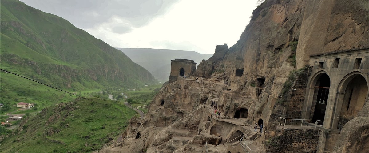 A mountainous landscape with ancient ruins and a winding road.