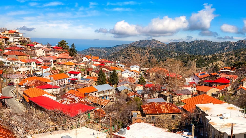 A hillside village with red-roofed houses and a church.