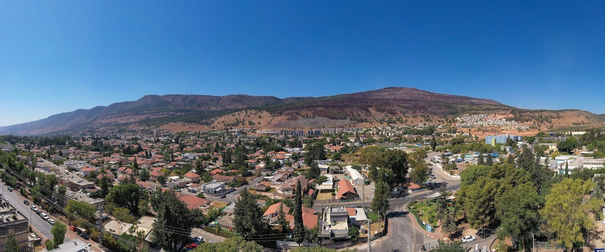A town with a mountain in the background and a mix of residential and commercial buildings.