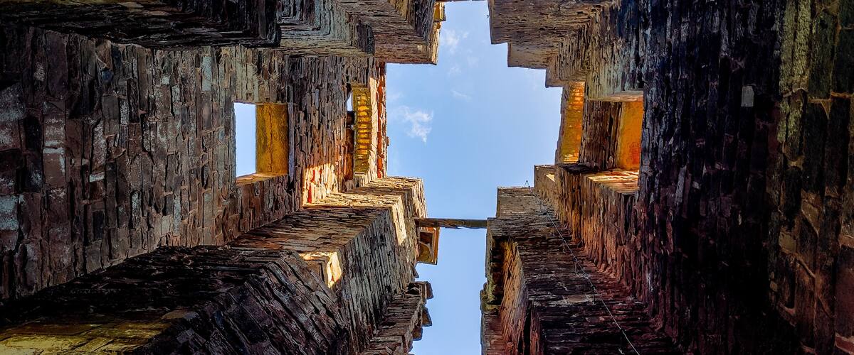A symmetrical stone structure with a clear sky visible through the gaps.