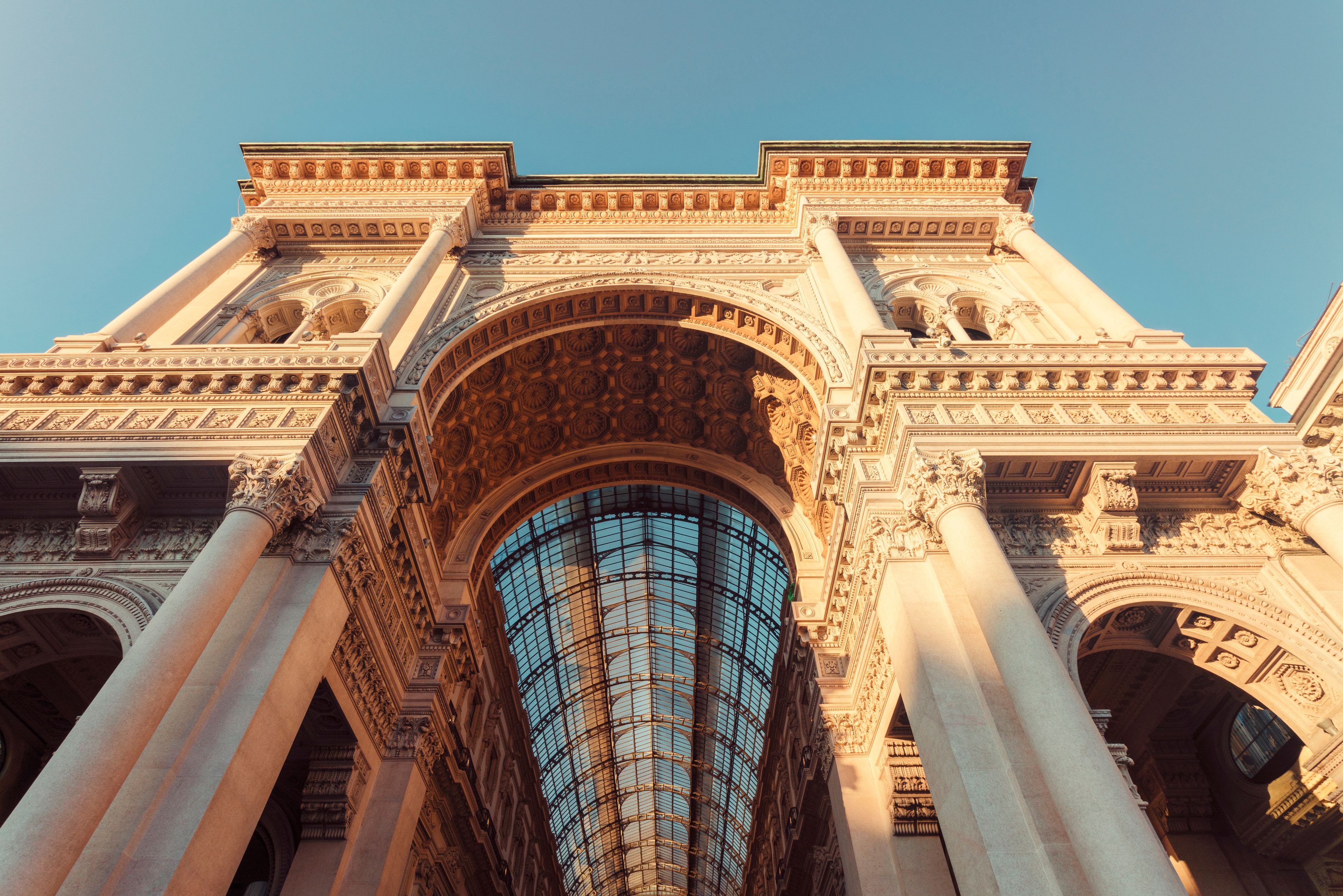 A grand architectural structure with ornate columns and a large arched window.