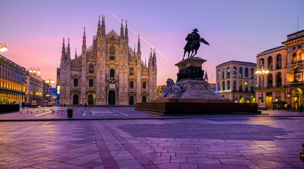A historic cathedral with intricate Gothic architecture, a statue of a historical figure on horseback, and a plaza with patterned paving.