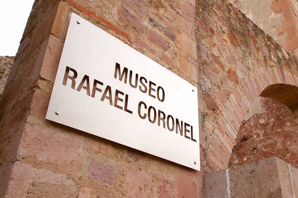 A sign reading "MUSEO RAFAEL CORONEL" mounted on a brick wall.