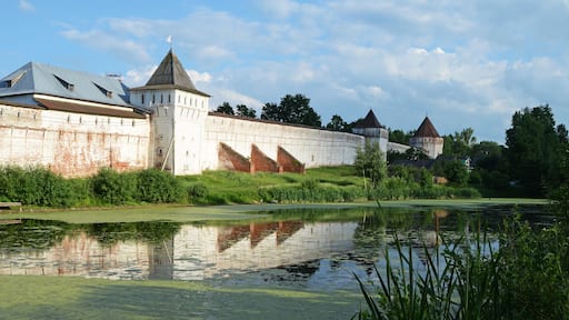 Une forteresse historique dotée d’un fossé, de murs en briques et surplombant un ciel dégagé.