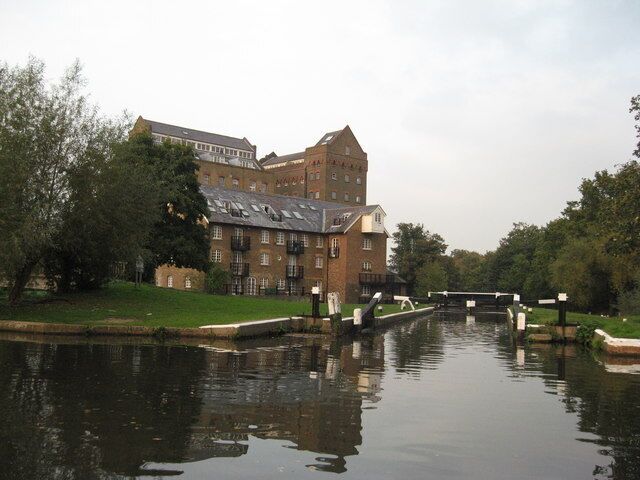 Coxes Mill, River Wey Navigation Coxes Mill is 1.5miles south of the Thames near Weighbridge. In 1776 an ironmaster recognised the potential the site offered and started to build his iron mill which became known as Coxes Lock Mill. It is generally regarded as industrially the most significant mill on the Wey, its importance reflected perhaps by the fact that it was not to finally close until 1983, making it the last commercially operated mill on the Wey Navigation. The mill was rebuilt in 1901 and extended in 1906, becoming one of the most important industrial buildings in the country at the time. The three mill buildings, having been listed for preservation under a Grade II category, were converted to residential use after its closure in 1983. (http://www.weyriver.co.uk/theriver/wey_nav_8.htm)